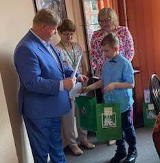uczeń odbiera nagrodę za konkurs bezpiecznie na wsi mamy, niebezpiecznych substancji unikamy